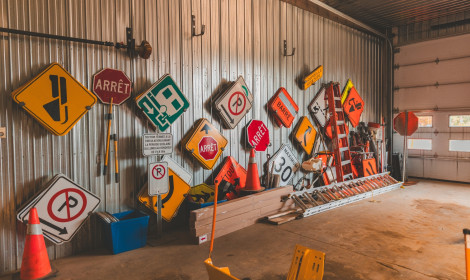 Une panoplie de pancartes accrochées sur le mur du garage municipal.