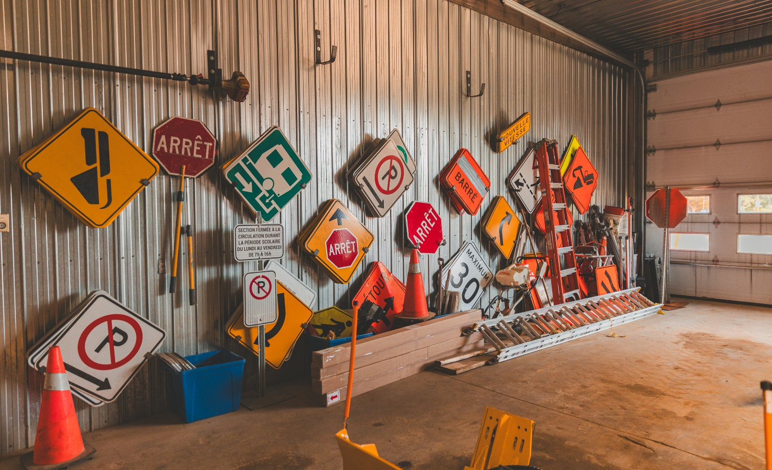 Une panoplie de pancartes accrochées sur le mur du garage municipal.